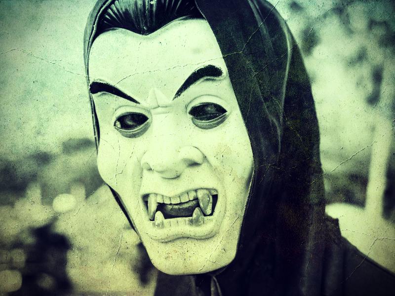 Fotografía de persona en primer plano con una cara de plástico de vampiro