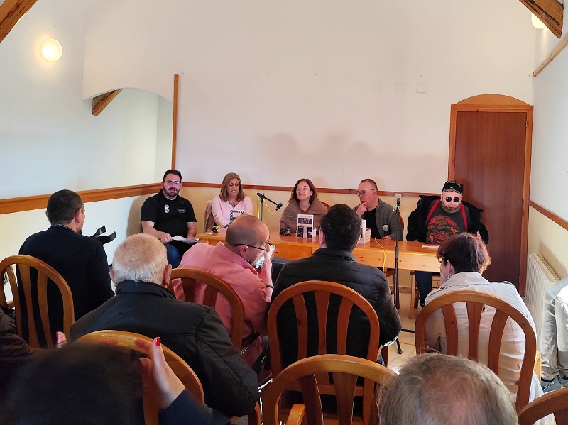 Centro Social de Bustares. Conferencia Escritura e Inclusión. Se ve la mesa con el coordinador y las autoras y autores de la conferencia. De izquieda a derecha: Miguel Llorente, Olga Luján, Guadalupe Iglesias, Pedro Pedraza y Lou Morrison